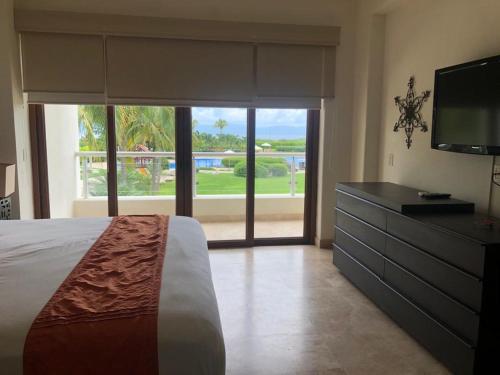 a bedroom with a bed and a dresser with a television at Condo exclusivo de 2rec en complejo B Nayar in Cruz de Huanacaxtle