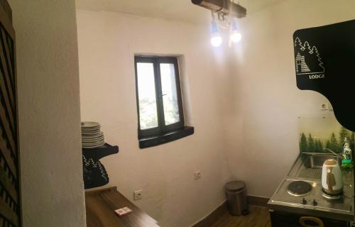 Elle comprend une petite cuisine avec un évier et une fenêtre. dans l'établissement Lodge Zbilje Visoko, Bosnian Pyramids, à Visoko