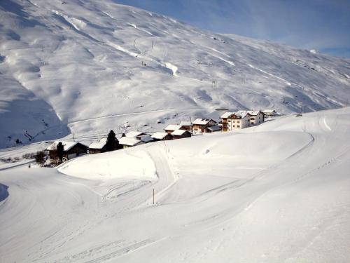 a snow covered mountain with a town on top of it at Ferienwohnung Stoffel in Cresta