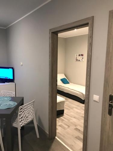 um quarto com uma porta que leva a um quarto com uma cama em Apartament C18 em Jelenia Góra