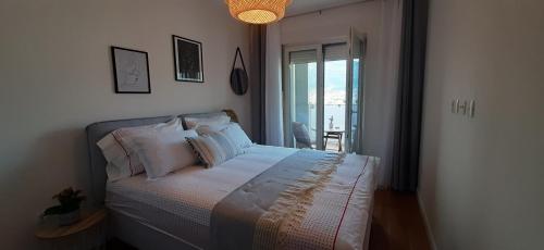 um quarto com uma cama com lençóis brancos e almofadas em Lux Apartment PortoVista em Bar