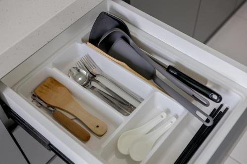 a drawer with utensils in a white container at Seaview Holiday Home, by Sanguine in Tanjong Tokong