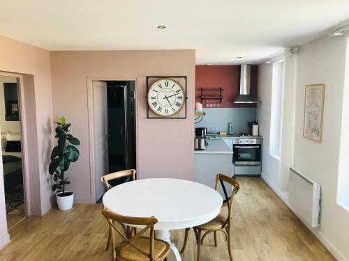 cocina con mesa y reloj en la pared en Escale face à la Loire en Chaumont-sur-Loire