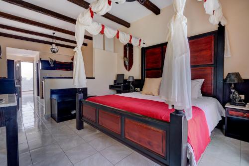 a bedroom with a large bed with a red blanket at Castello Di Cavallieri Suites & Spa - Adults Only in Faliraki