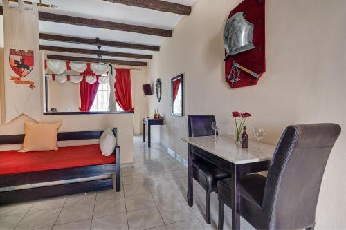 a living room with a table and a couch and a bed at Castello Di Cavallieri Suites & Spa - Adults Only in Faliraki
