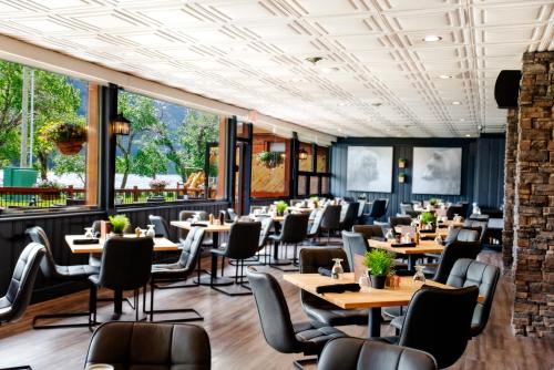 a restaurant with tables and chairs and windows at Bayshore Inn & Spa in Waterton Park