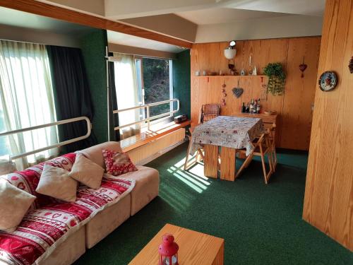 a living room with a couch and a table at Vetrate sul bosco in Marilleva