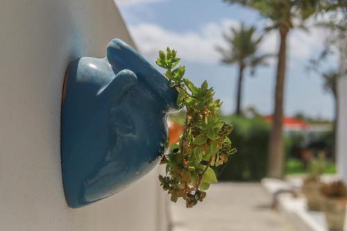 a blue bird shaped door knob with a plant at Dar El Jerbi in Mezraya