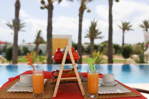 a table with a tray of food and drinks next to a pool at Dar El Jerbi in Mezraya