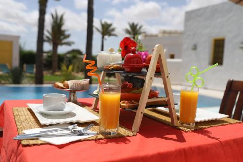 a table with a tray of food and orange juice at Dar El Jerbi in Mezraya