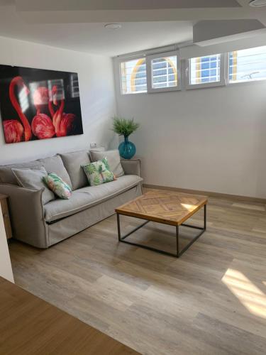 a living room with a couch and a coffee table at HOTEL apartamentos SEVEN ROOMS in Punta Umbría