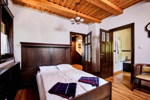 a bedroom with a large bed with a wooden headboard at Villa Szalamandra - az Erdőszéle in Matraalmas