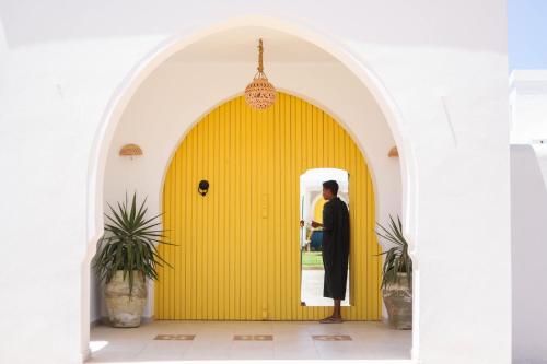 a man standing in front of a yellow door at Dar El Jerbi in Mezraya