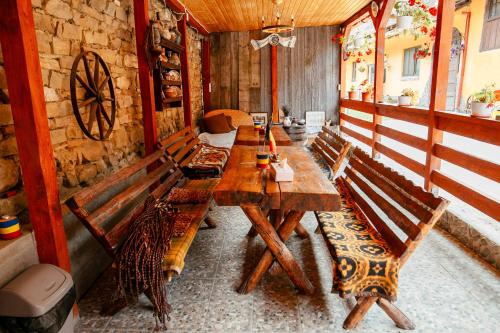 a room with a long wooden table and benches at Casa pe Valea Hartibaciului(Bărcuț) in Bărcuţ