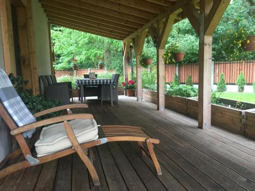 a wooden porch with a rocking chair on a deck at Domek na wsi Mokosz in Kwilcz