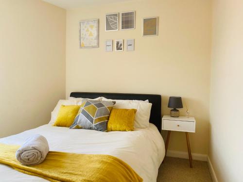 a bedroom with a bed with yellow pillows at Silver Stag Properties, Comfy 2 BR Home in Ashby in Smisby