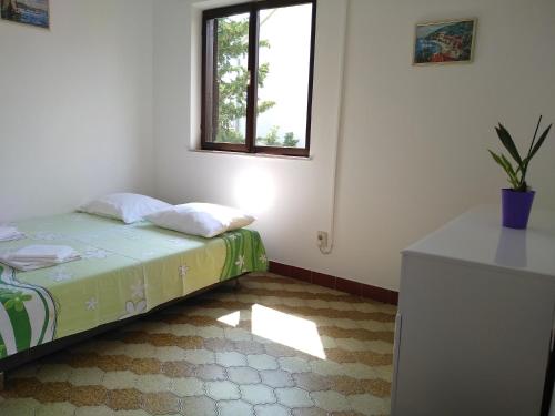 a small bedroom with a bed and a window at Apartments Vrsalovic in Bol
