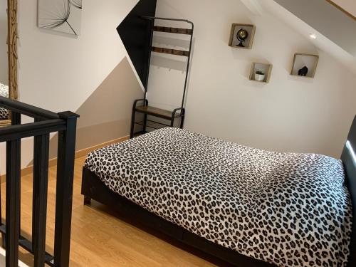 a bedroom with a leopard print bed and a ladder at Petite maison atypique cocooning in Raon-lʼÉtape