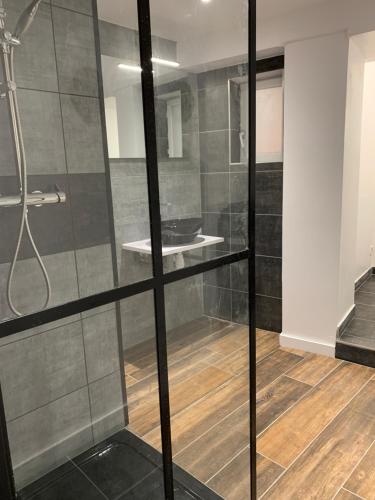 een badkamer met een douche en een glazen wand bij Petite maison atypique cocooning in Raon-lʼÉtape