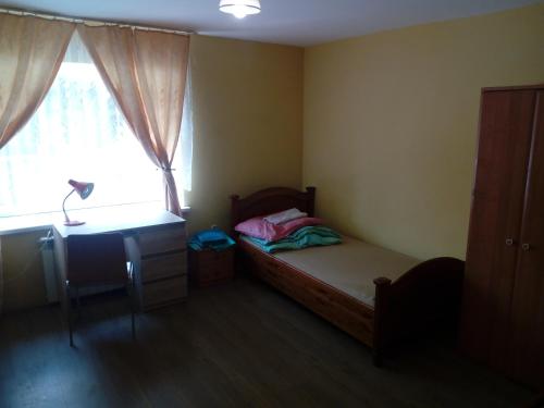 a bedroom with a bed and a desk and a window at U Bronka w Książęcym Lesie in Niedaszów