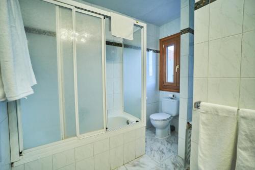 a bathroom with a shower and a toilet at Hostal El Panadero in Sepúlveda