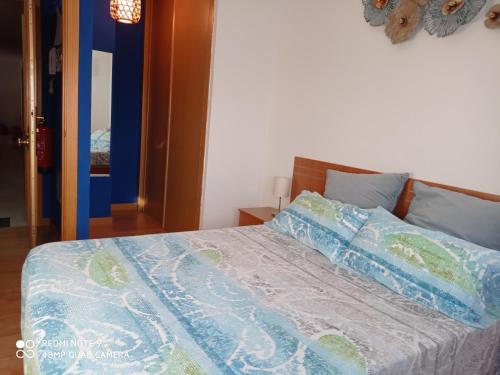 ein Bett mit einer blauen und weißen Bettdecke darauf in der Unterkunft Deep Blue Inn in Torrecaballeros