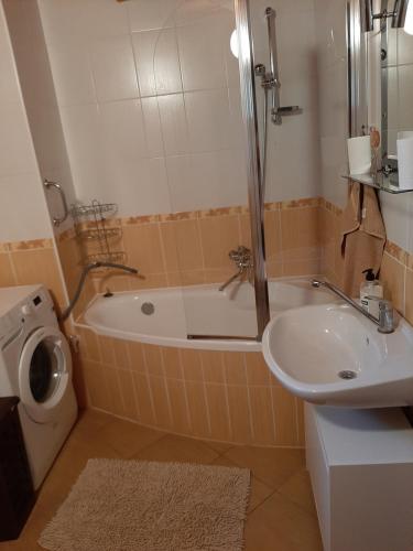 a bathroom with a tub and a sink and a toilet at Chata Konzajf in Hrabušice