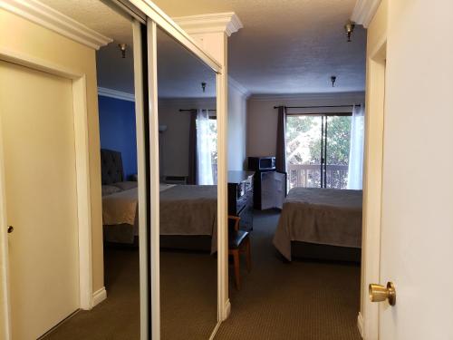 a room with two beds and a mirror at Olympic Suites B08 in Los Angeles