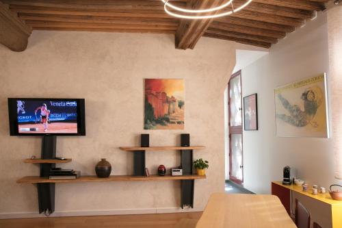 圖爾尼的住宿－Spacieux appartement, A-mi-chemin, au coeur de Tournus，客厅的墙上配有电视