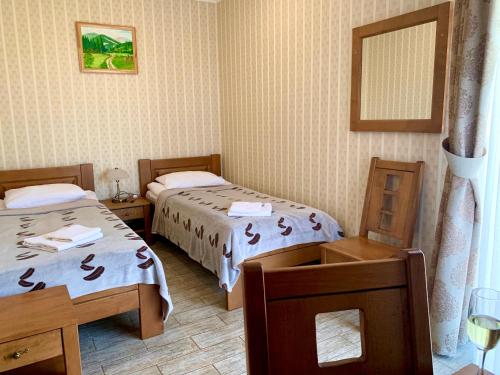 two beds in a room with a table and chairs at Mini hotel Solnce Karpat in Polyana