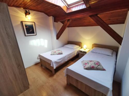 a bedroom with two beds and a skylight at Apartments Sokolic in Nerezine
