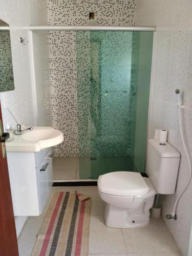 a bathroom with a toilet and a sink and a shower at Casa a 3 minutos da praia in Saquarema