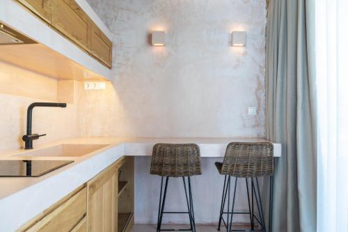 a kitchen with a sink and two bar stools at Fillis House in Vourvourou