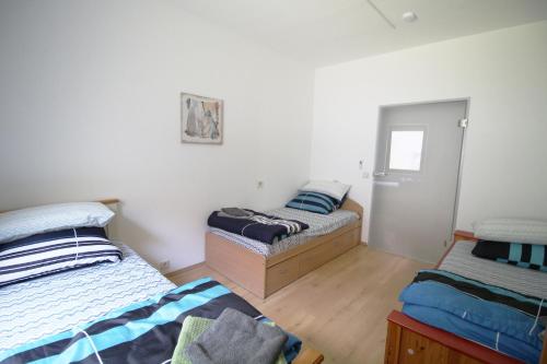 two beds in a room with white walls and wooden floors at Work & Stay in Niederstotzingen in Niederstotzingen