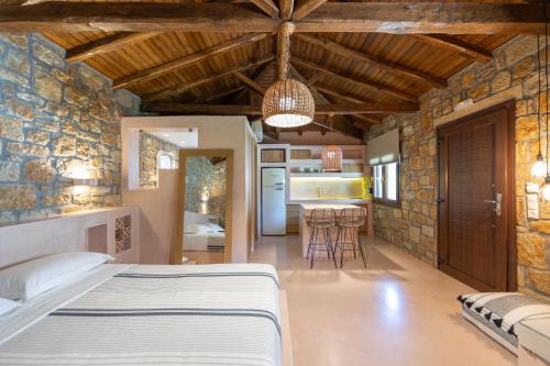 a bedroom with a bed in a room with a kitchen at Fillis House in Vourvourou