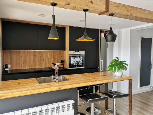 a kitchen with a wooden counter and black walls at Oroel in Jaca