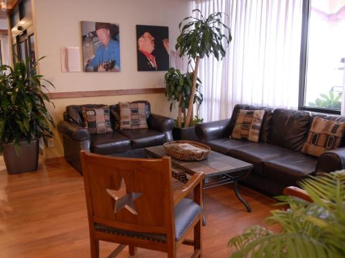 a living room with a leather couch and a table at Wyndham Garden Hotel Austin in Austin
