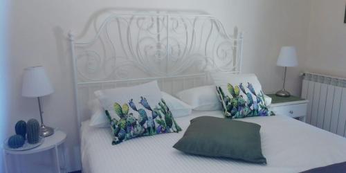 a white bed with a white headboard and pillows at Etna Sicilian House in Linguaglossa