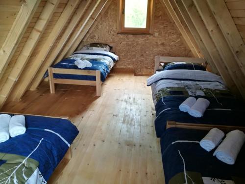 a room with three beds in a log cabin at Camp Volujak in Volujak