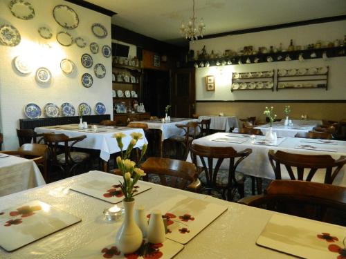 Lanchester的住宿－皇家橡木賓館，餐厅墙上设有桌椅和盘子