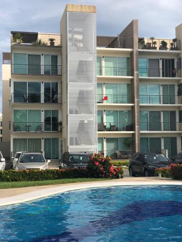 a large apartment building with a swimming pool in front of it at Departamento Acapulco Diamante in Acapulco