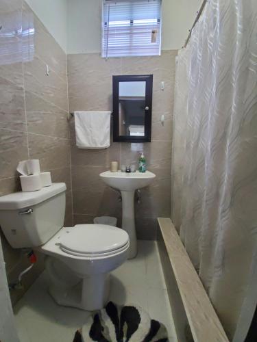 a bathroom with a toilet and a sink at Private 3 Bedroom Villa in Hagatna