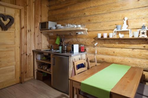 a kitchen with a stove and a table in a cabin at Manka Kisrönkház in Ispánk