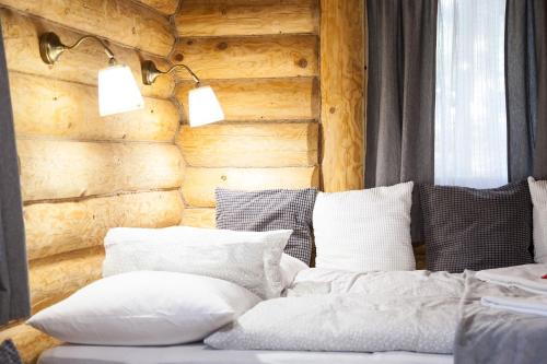 a room with a couch with pillows and a wooden wall at Manka Kisrönkház in Ispánk