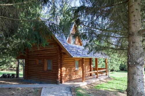 a log cabin in the woods with a tree at Manka Kisrönkház in Ispánk