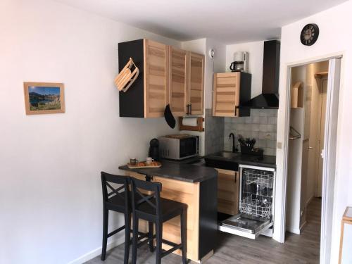 - une petite cuisine avec un comptoir et des chaises dans l'établissement Studio chaleureux à la Foux D’Allos, à Allos