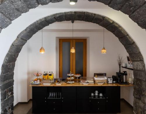 an archway in a kitchen with a table with food at Hotel Arcanjo in Rosário-Lagoa