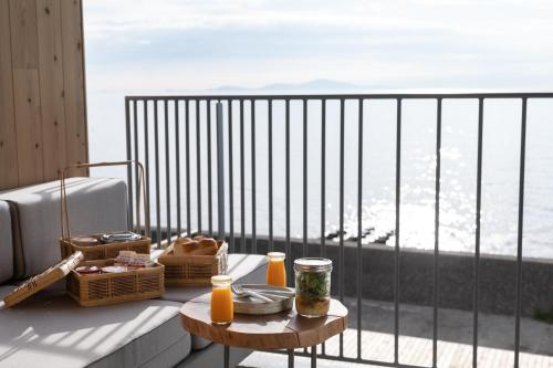 a table on a balcony with a view of the ocean at KAMOME SLOW HOTEL in Awaji