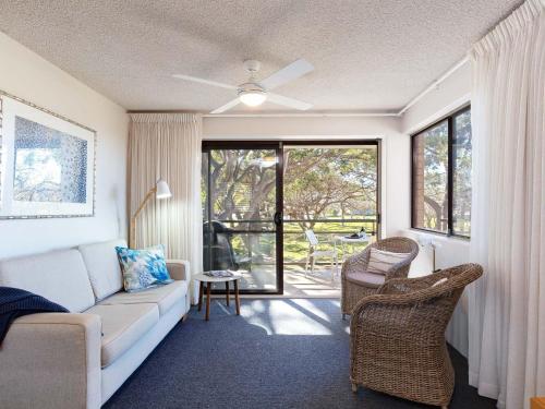 uma sala de estar com um sofá e uma janela em Intrepid 1 3 Intrepid Close Amazing views of Shoal Bay only 100m from the Beach em Shoal Bay