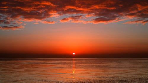 a sunset over the ocean with the sun in the sky at istanbul Airport Kumsal Otel in Arnavutköy